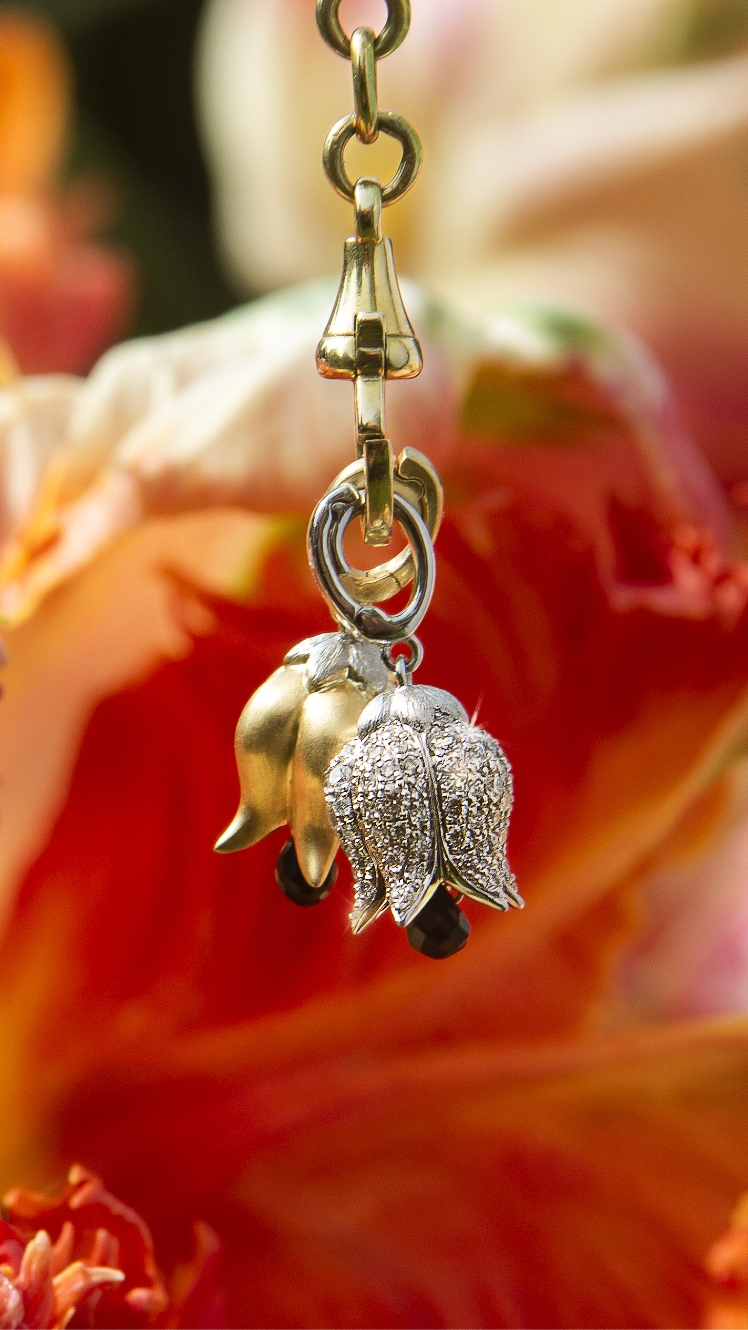 gold and diamond tulip charms in front of tulips